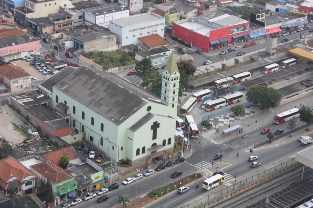Foto aérea com a igreja verde no centro da foto, ao lado está a estação de trem de Guaianases
