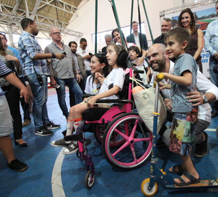 Prefeito Bruno Covas com várias crianças com deficiência.