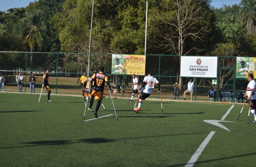 Jogadores amputados durante partida em campo de futebol aberto.