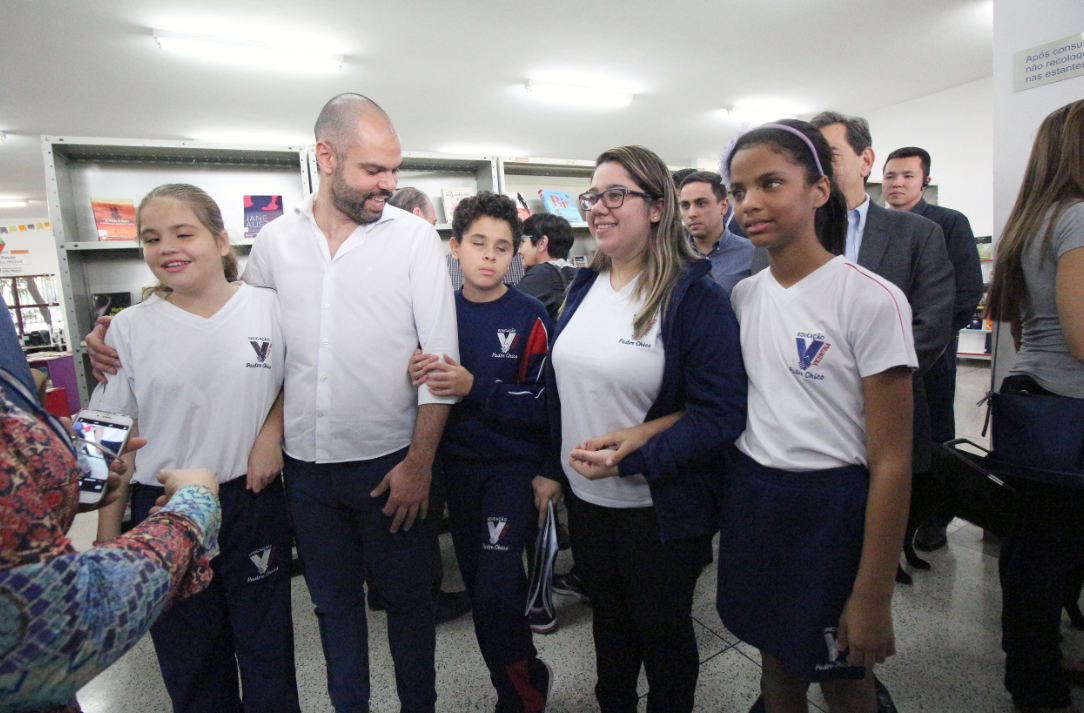 O prefeito Bruno Covas conversa com algumas crianças com deficiência visual.