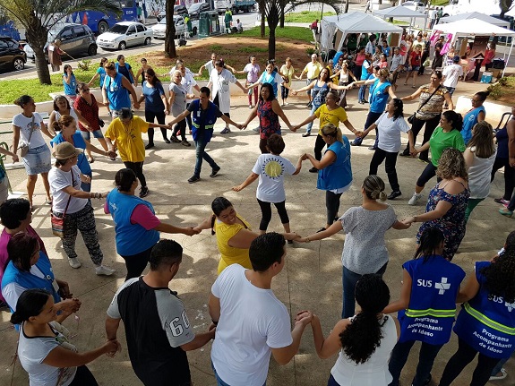 Funcionárias e pacientes dançam de mãos dadas em forma de ciranda