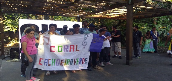 Participantes do coral exibem nome do coral Cachoeira Verde escrito em letras coloridas em fundo branco