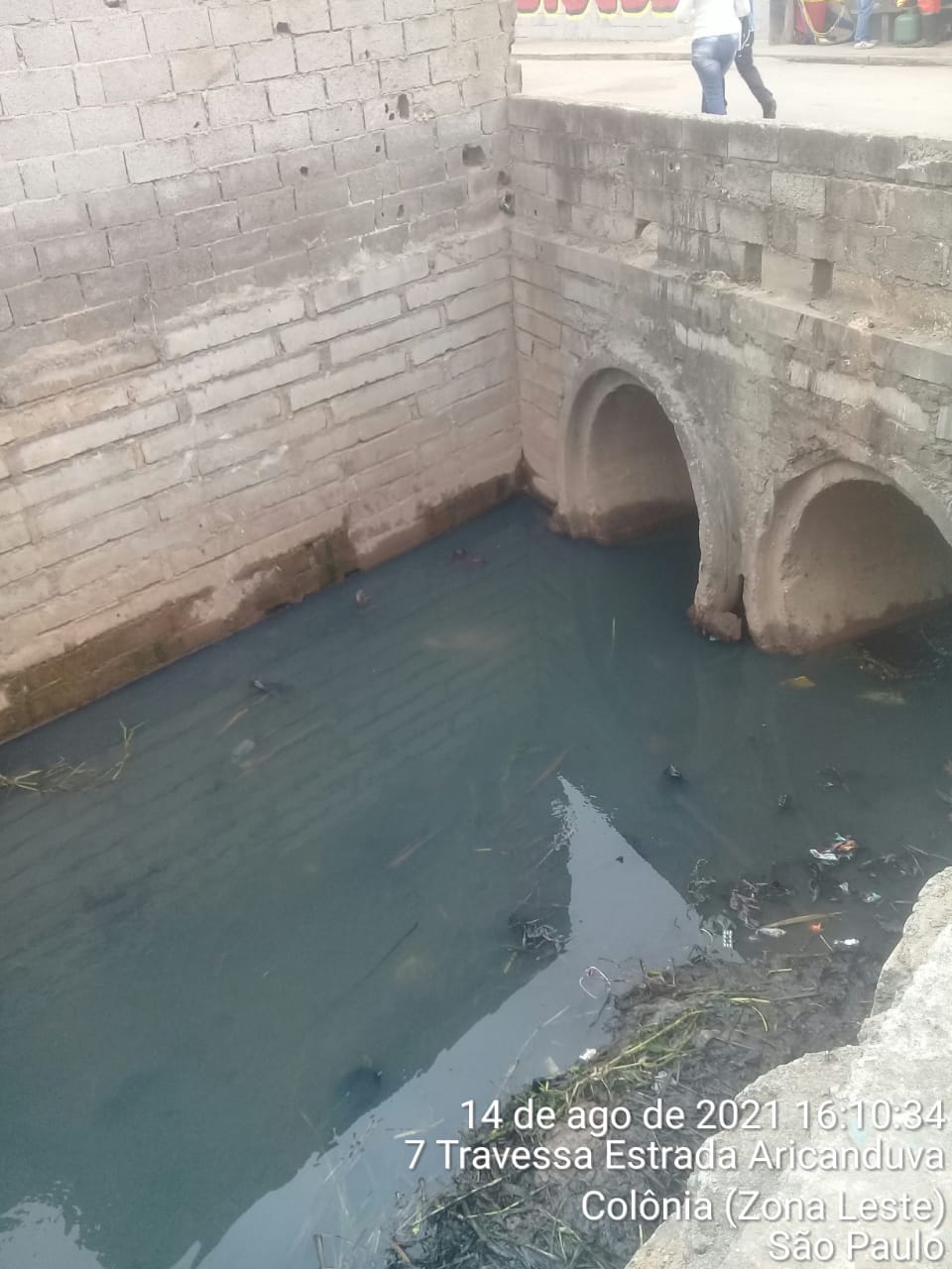 Duas bocas de saída de água em tubos de concreto, com água poluída. A sujeira foi retirada. 