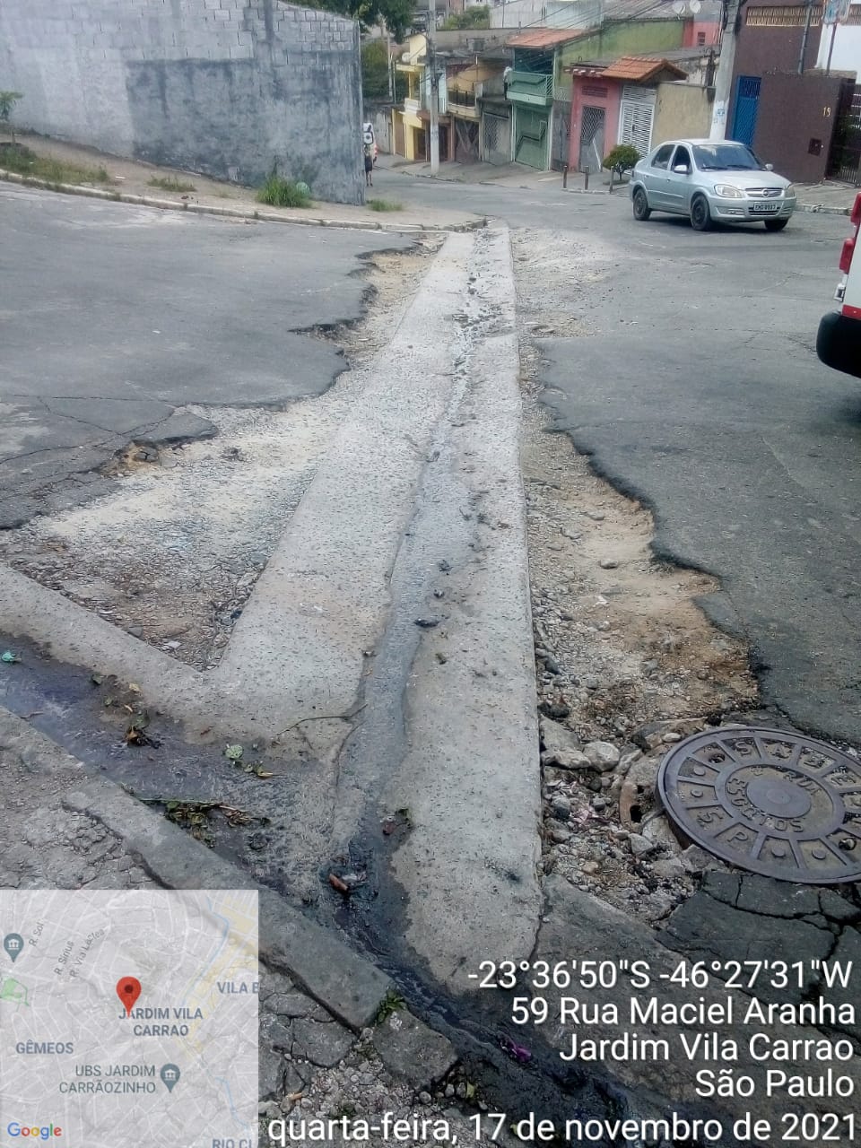 Uma rua está com o Sarjetão reformado, faltando o alinhamento com o asfalto, com uma valeta nas duas bordas. 