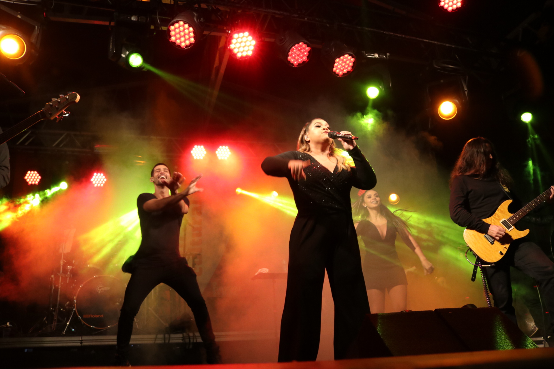 Cantora Preta Gil canta com bailarinos ao fundo do palco 