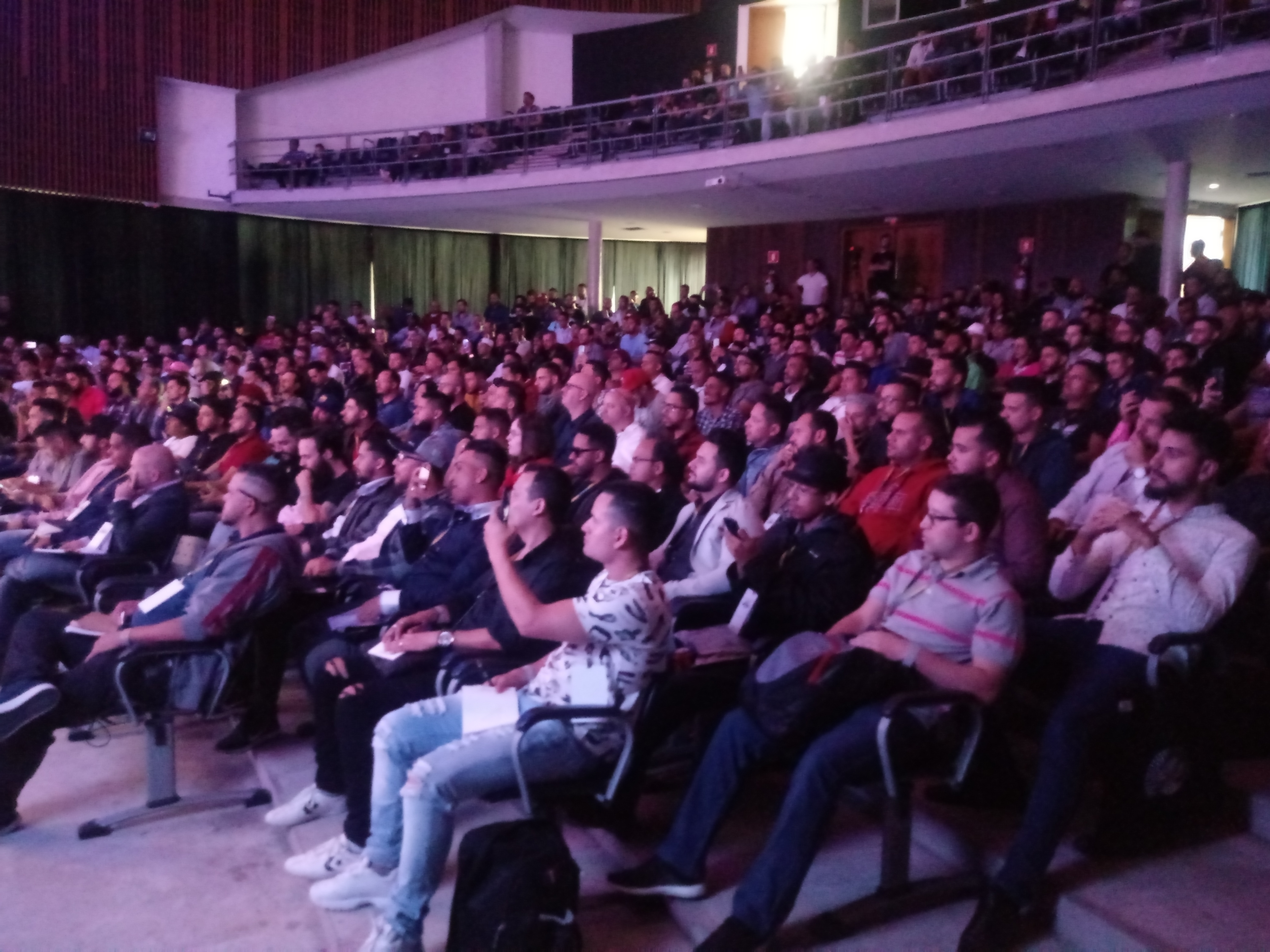 Auditório do Teatro Caritas está lotado, com a participação de 600 cabeleireiros. A maioria é do sexo masculino. Eles olham para o palco.