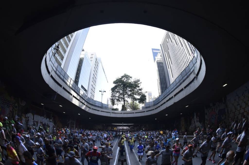 Foto colorida dos corredores no Túnel da Avenida Paulista 