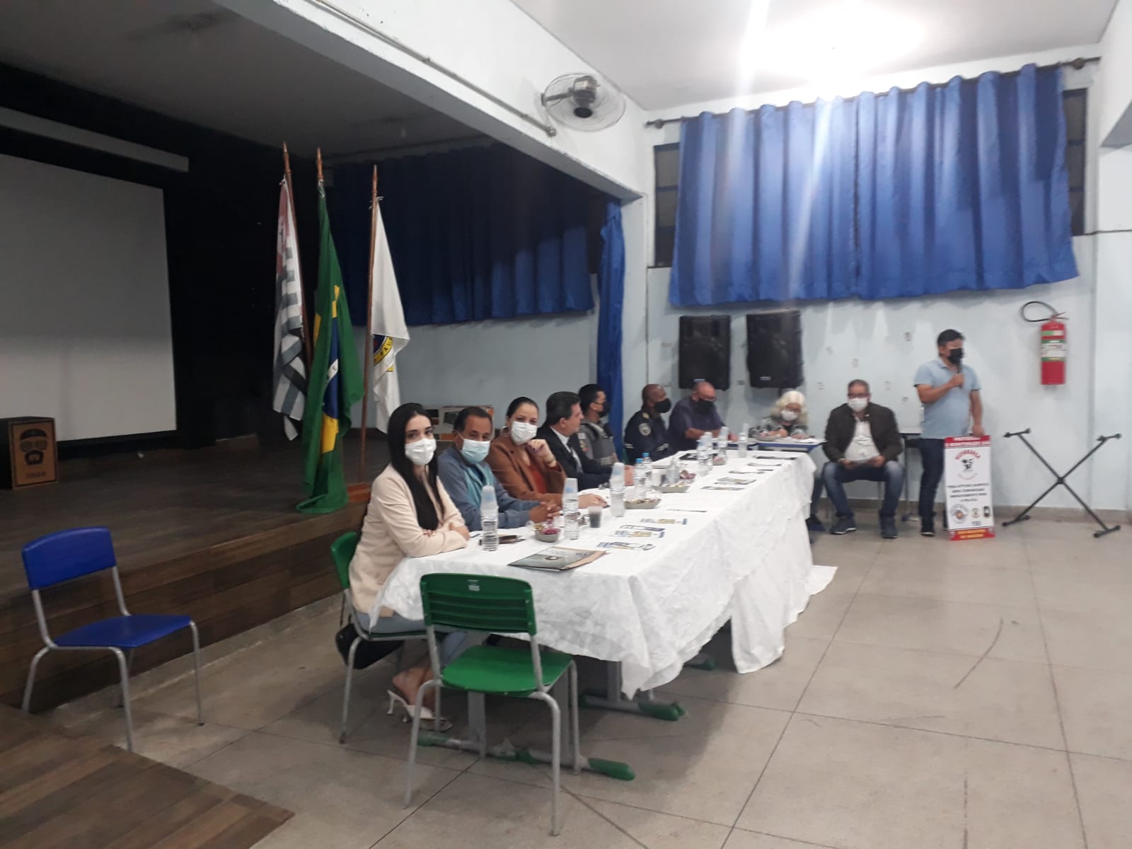 Representantes do Conseg e autoridades convidadas estão sentados atrás de uma mesa comprida, forrada com toalha branca