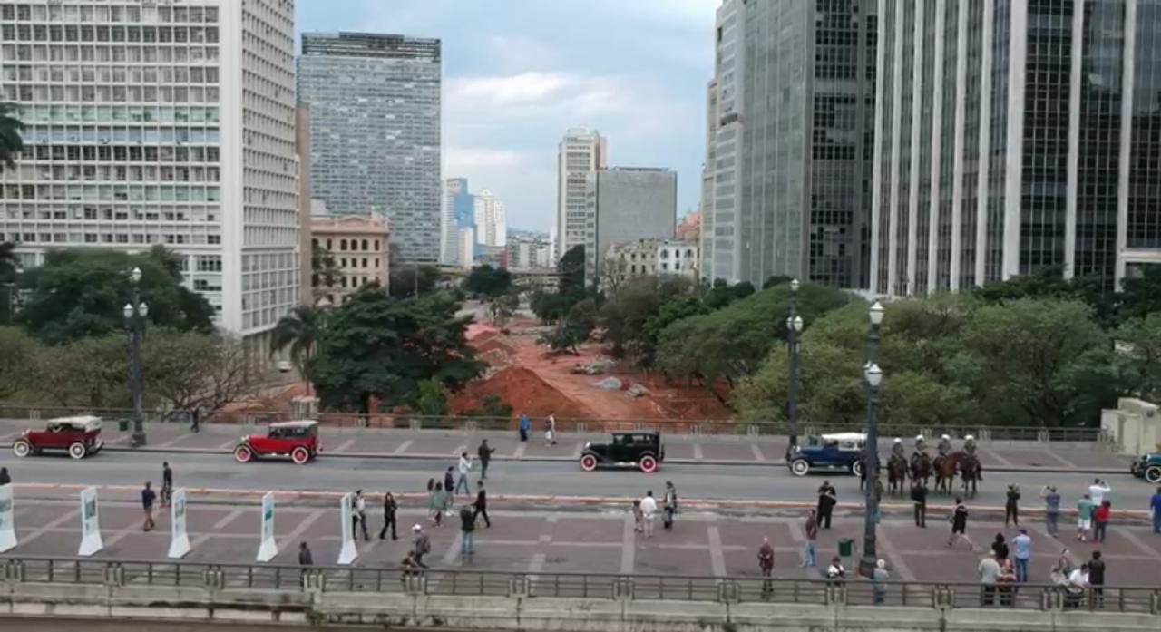 Foto colorida com imagem aérea do Viaduto do Chá com carros. E ao fundo o Vale do Anhangabaú e o prédios