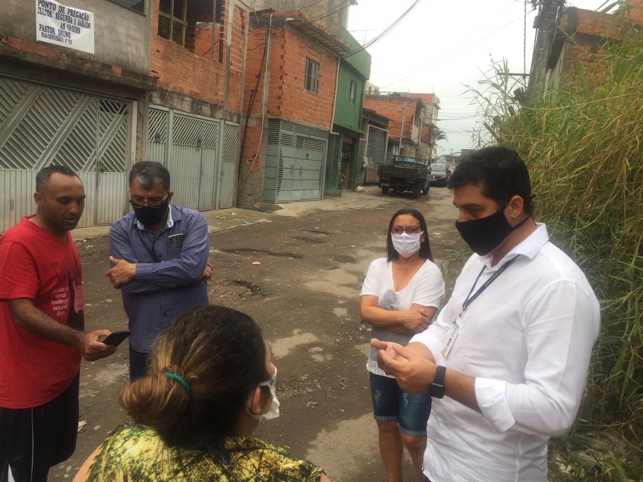 Subprefeito e coordenador da CPDU conversam com lideranças do Jardim Elizabteth, em uma rua. 