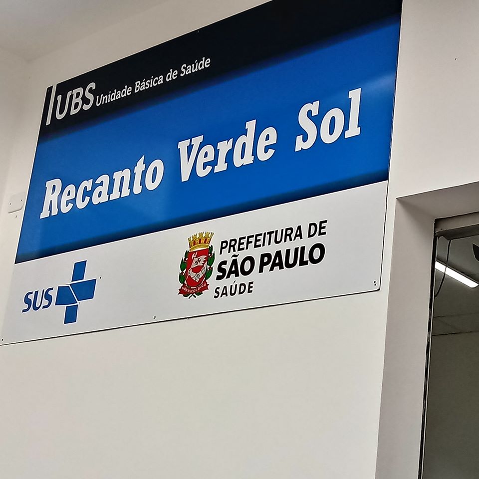 Placa azul com os dizeres: "UBS Unidade Básica de Saúde" "Recanto Verde Sol"