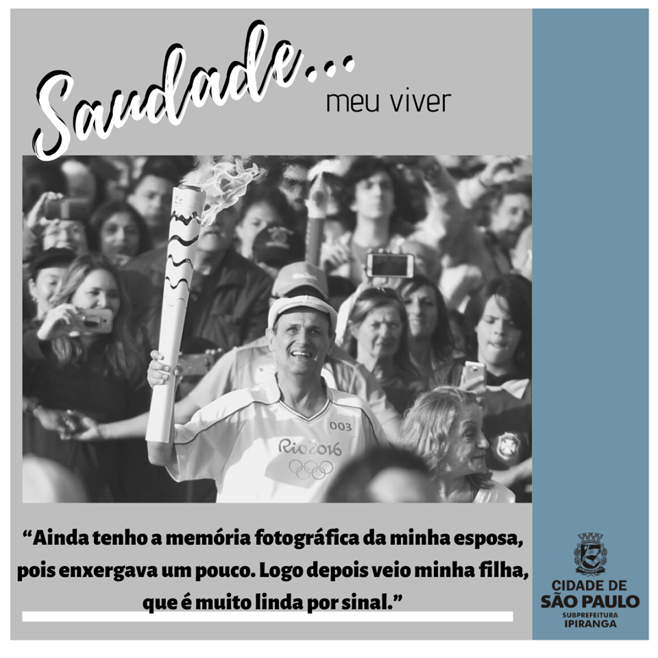 Em preto e branco, o entrevistado Vicente veste uma camiseta com a inscrição Rio 2016, enquanto segura a pira olímpica, cercado de pessoas.