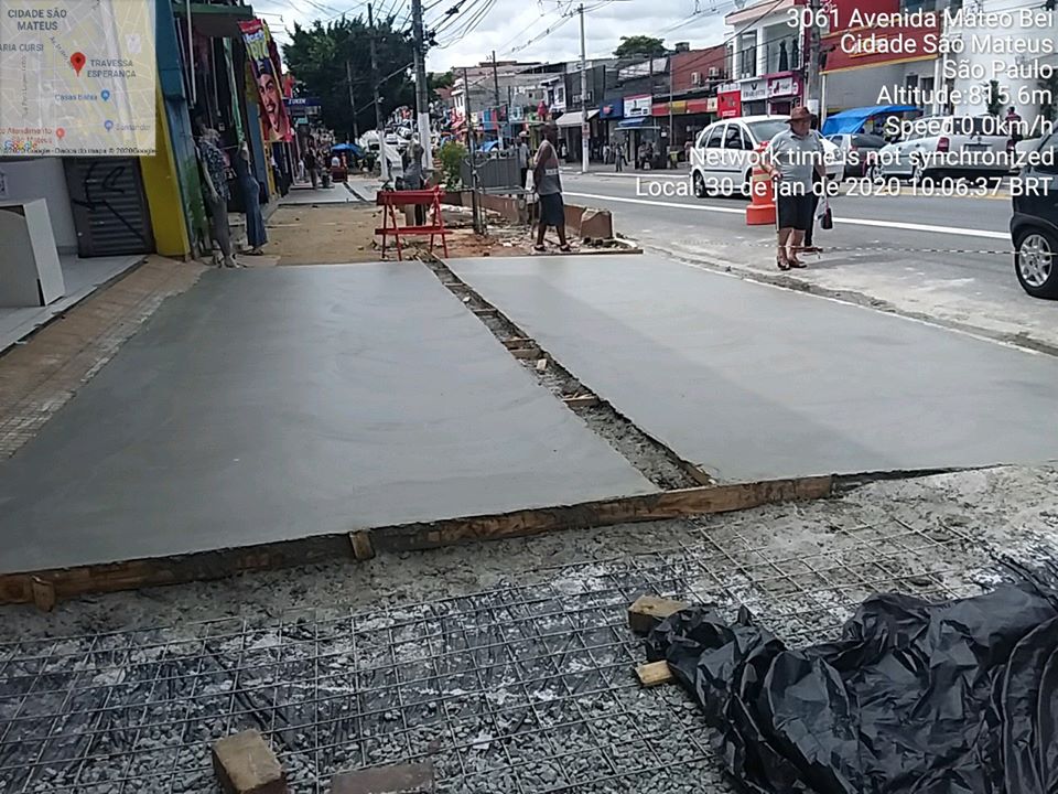 Trecho de calçada está com o cimento liso. No outro, um fundo de plástico, com grade de ferro, pronta para a colocação do concreto.