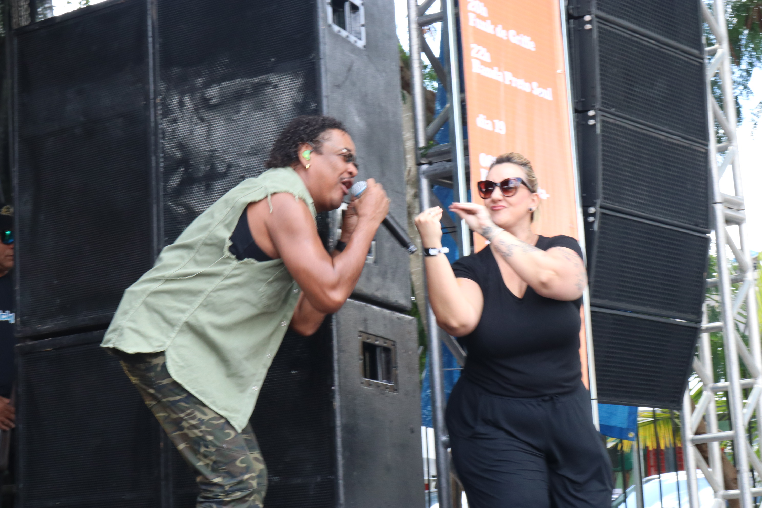 Vocalista Cumpadre Washington canta ao lado de mulher interprete de libras no palco