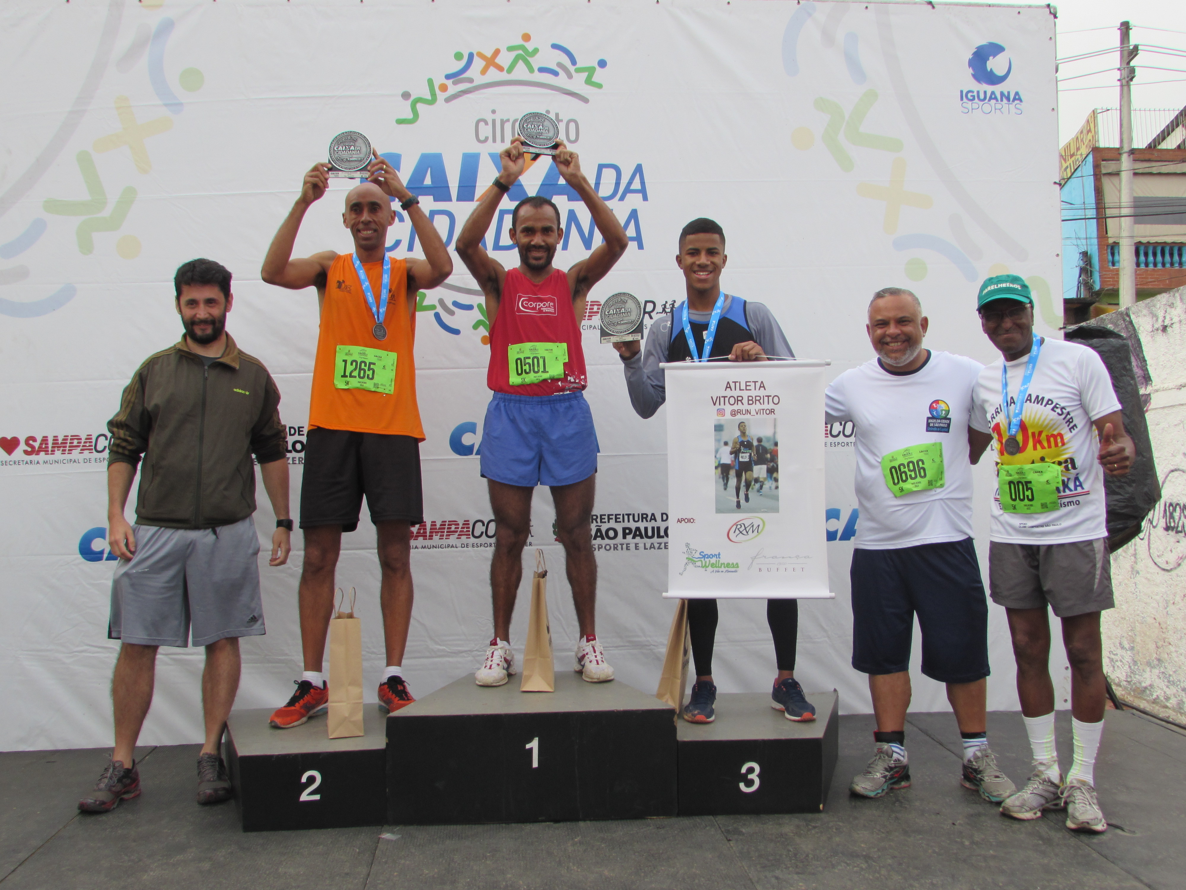 Podium masculino com os três vencedores e ao lado o Supervisor de Esportes da Subprefeitura Parelheiros e o Subprefeito Adailson de Oliveira