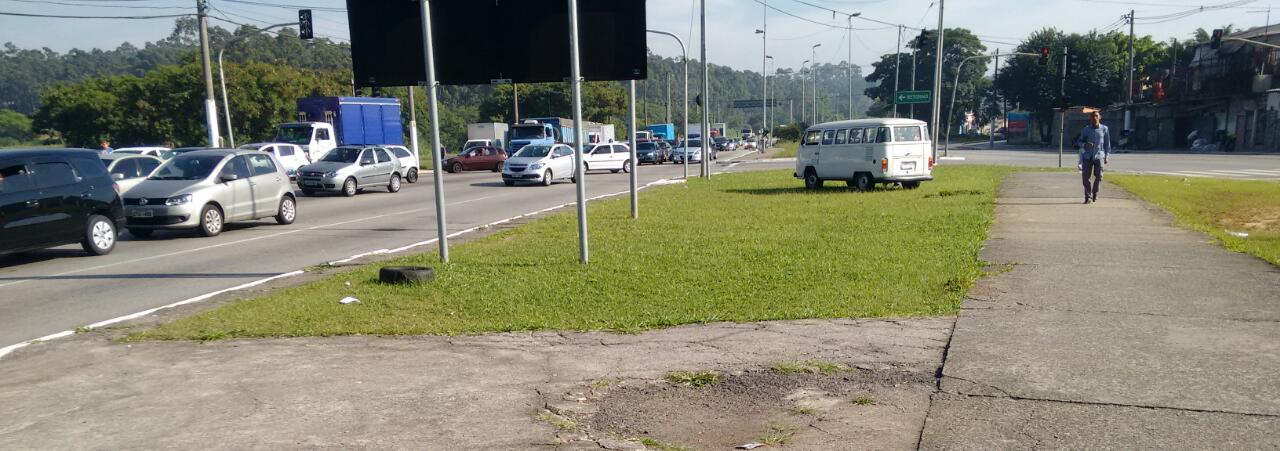 A foto com carros ao fundo, mostra em primeiro plano a Rotatória da avenida Jacu Pêssego antes de ter mudas de plantas