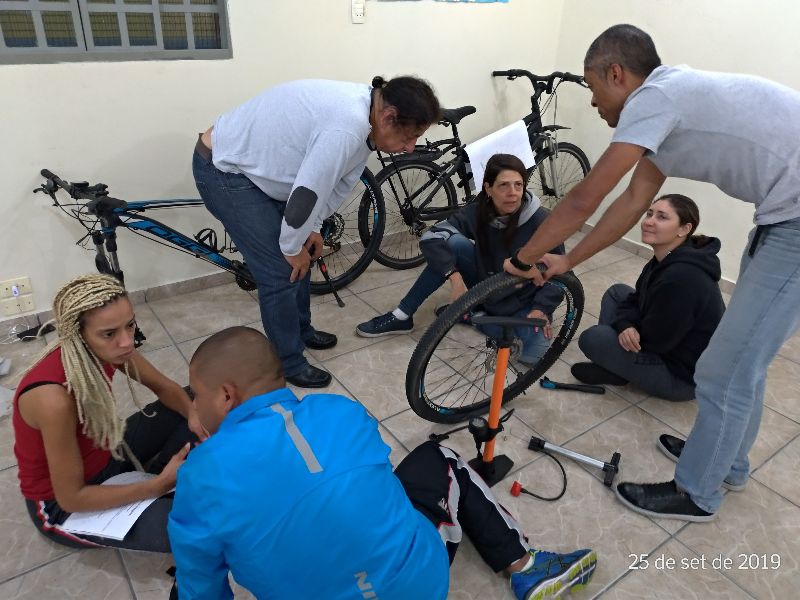 na foto os oficineiros conversando enquanto olham as bikes