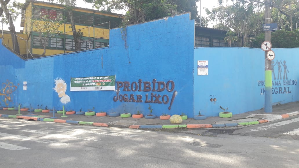A foto mostra a Av. Afonso Lopes de Baião após a revitalização, sem lixo e com o muro pintada de cores coloridas 
