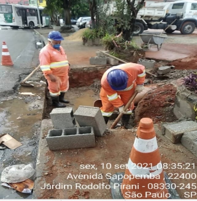 Dois homens trabalham dentro de um buraco, fazendo escavação manual, para a construção de uma galeria. Na Av. sapopemba, 22400, Jardim Rodolfo Pirani. 