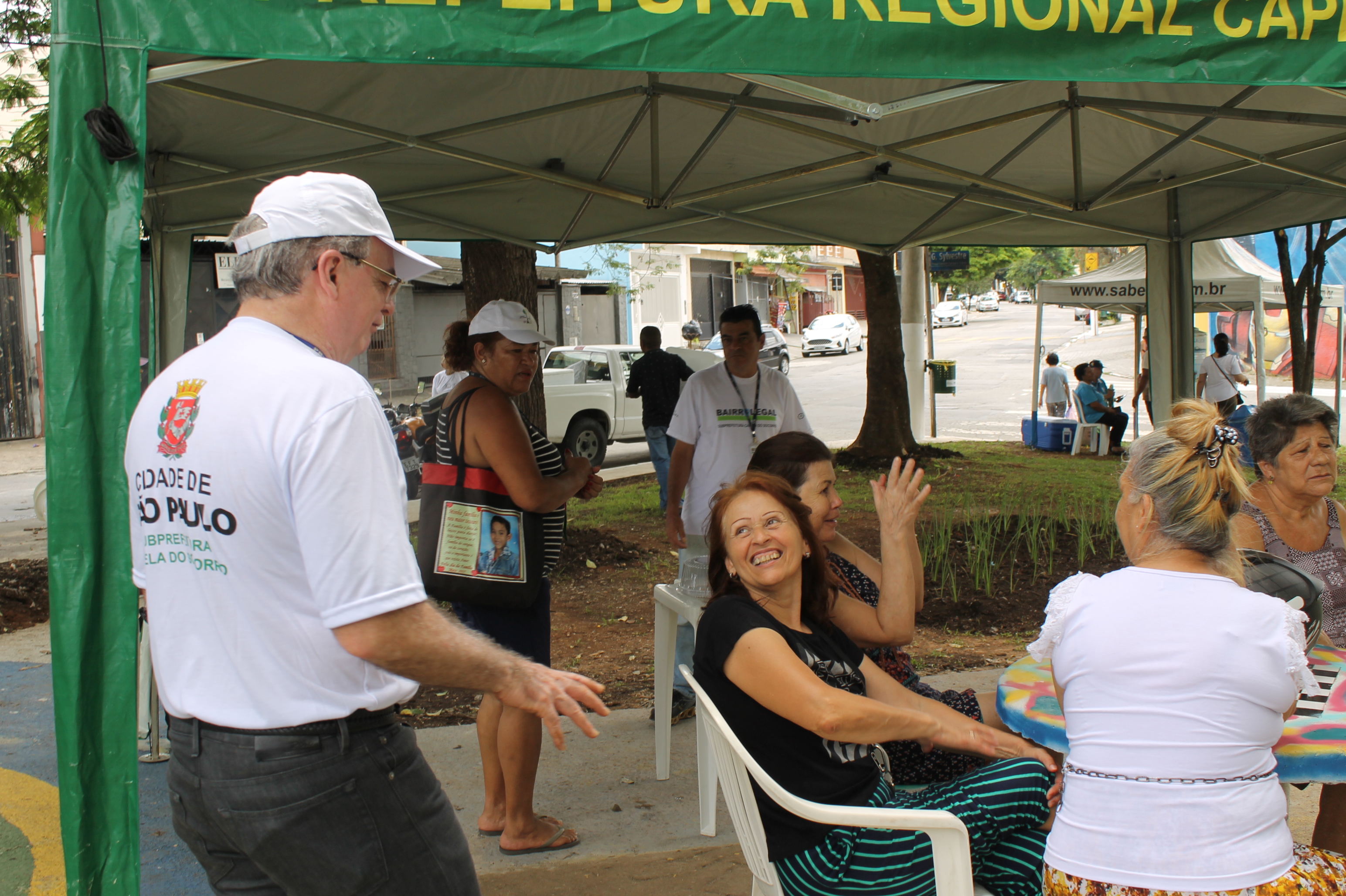 #PraCegoVer - O subprefeito João Batista de Santiago (à esquerda) com moradores da vizinhança, na tenda em que foi oferecido um café da manhã.