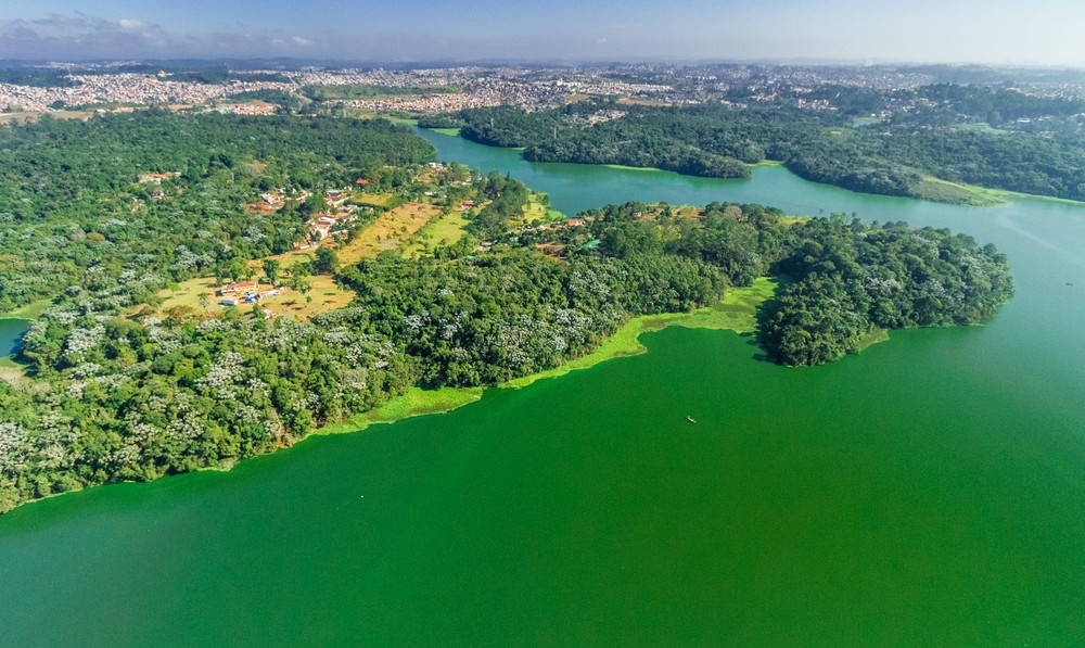 #PraCegoVer - Foto aérea do parque Bororé: vegetação às margens da represa Billings.