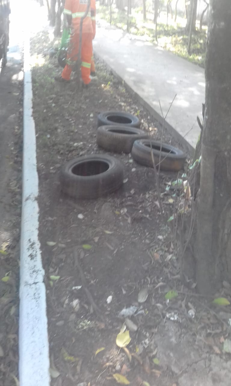 #PraCegoVer - No canteiro da avenida Teotônio Vilela, no Grajaú, veem-se quatro pneus velhos, que estão   sendo recolhidos por trabalhadores da Subprefeitura.