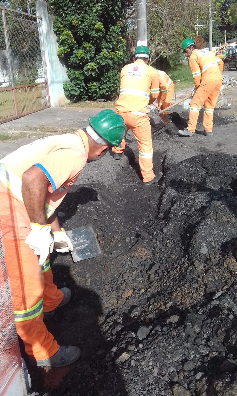 #PraCegoVer - Trabalhadores escavam o meio-fio para instalação de guias