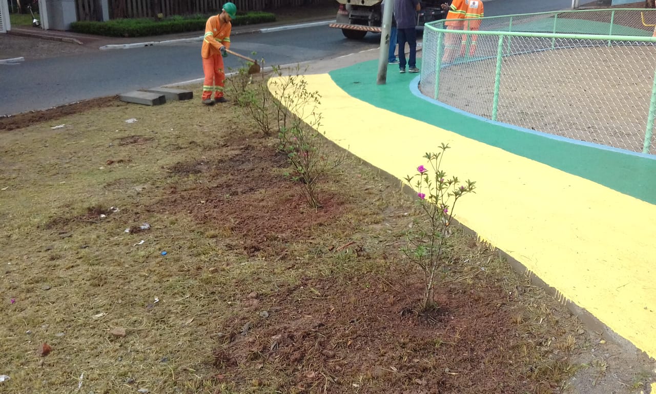 #PraCegoVer - Trabalhadores plantam mudas de flores e finalizam pintura de passeios na praça