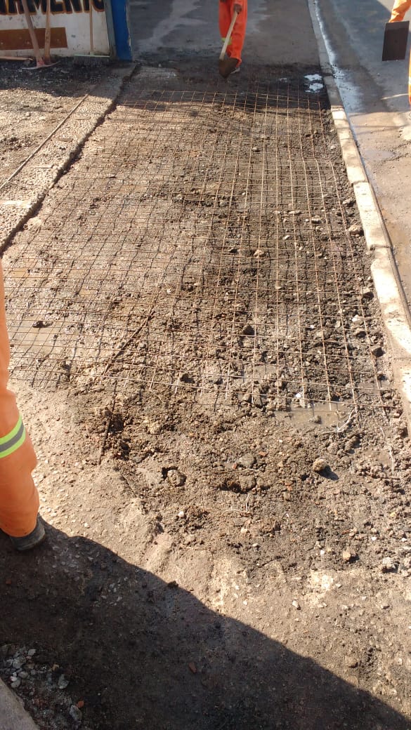 #PraCegoVer - Passeio da rua foi coberto por um trançado de barras de ferro, que serão concretadas. Dois trabalhadores da Subprefeitura terminam a colocação dos ferros.