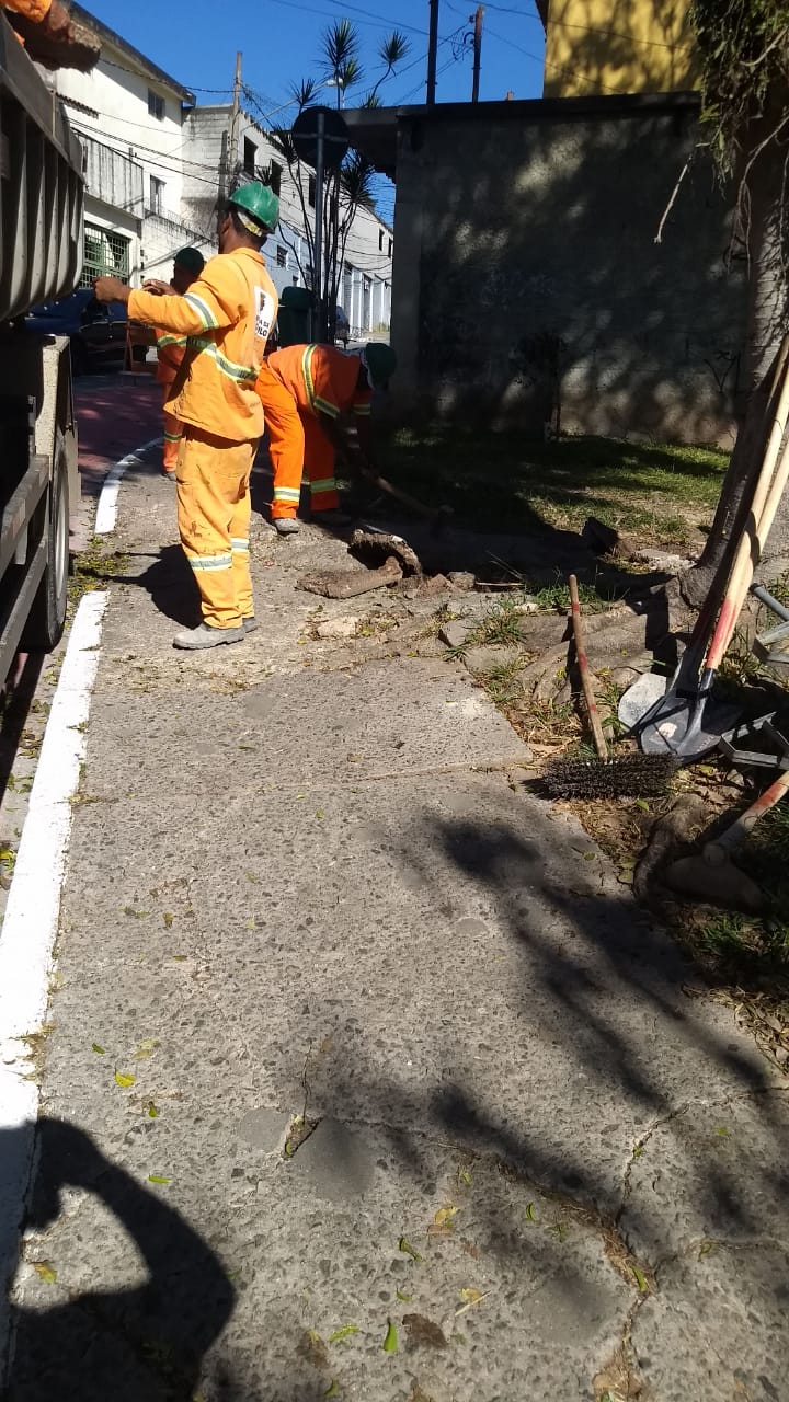 #PraCegoVer - Três trabalhadores da Subprefeitura escavam o passeio para posterior reconstrução