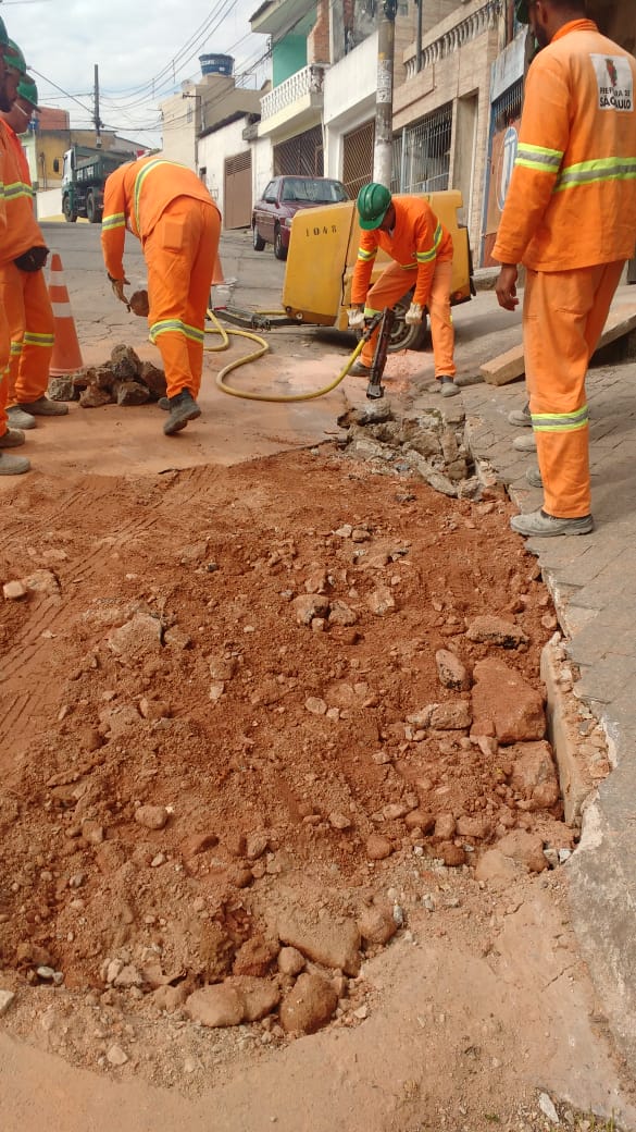 #PraCegoVer - Quatro trabalhadores da Subprefeitura abrem o piso da rua para iniciar a construção de sarjeta e assentamento de novas guias.