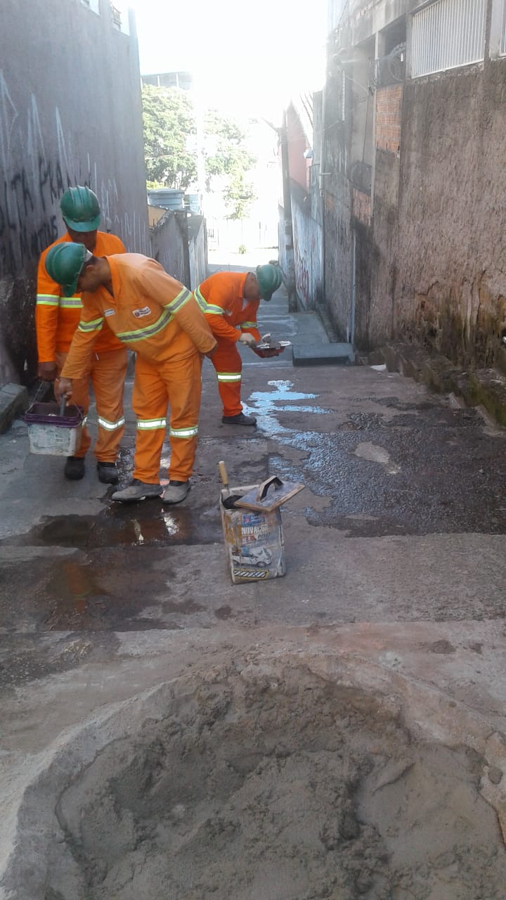 #PraCegoVer - Três trabalhadores da Subprefeitura preparam massa de cimento para aplicação no escadão. Estão na parte de cima do escadão, onde também se encontra a massa de concreto.