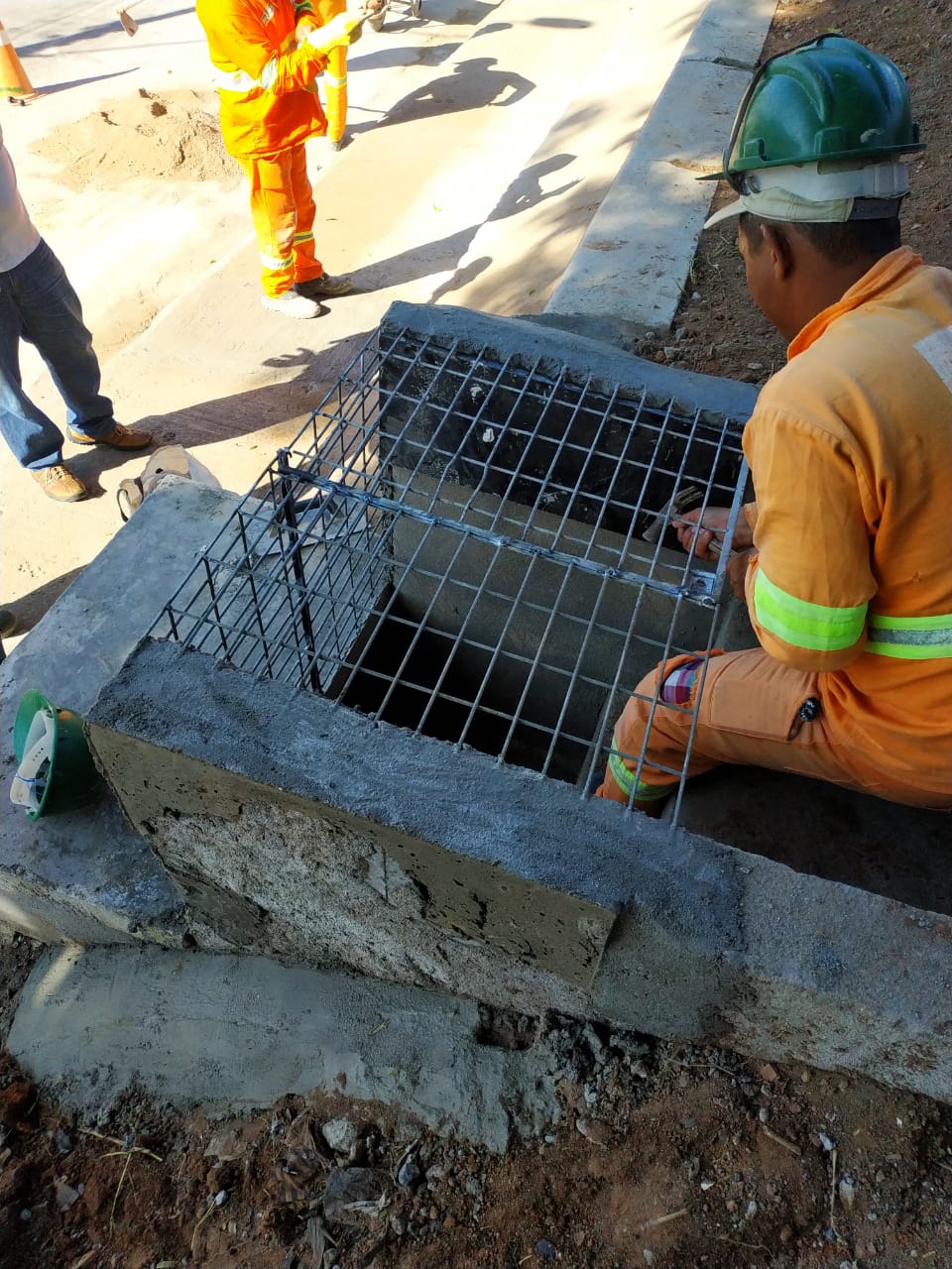 #PraCegoVer - Trabalhador da Subprefeitura termina de instalar grade de proteção no pé de uma escada hidráulica.