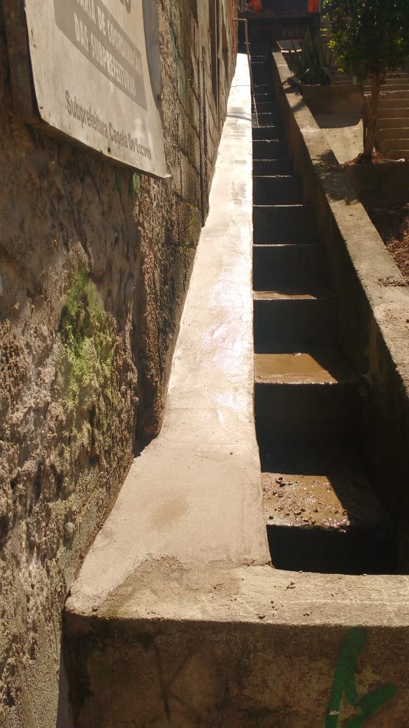 #PraCegoVer - Escada hidráulica ao lado de escadão. Do lado esquerdo, a proteção foi cimentada.