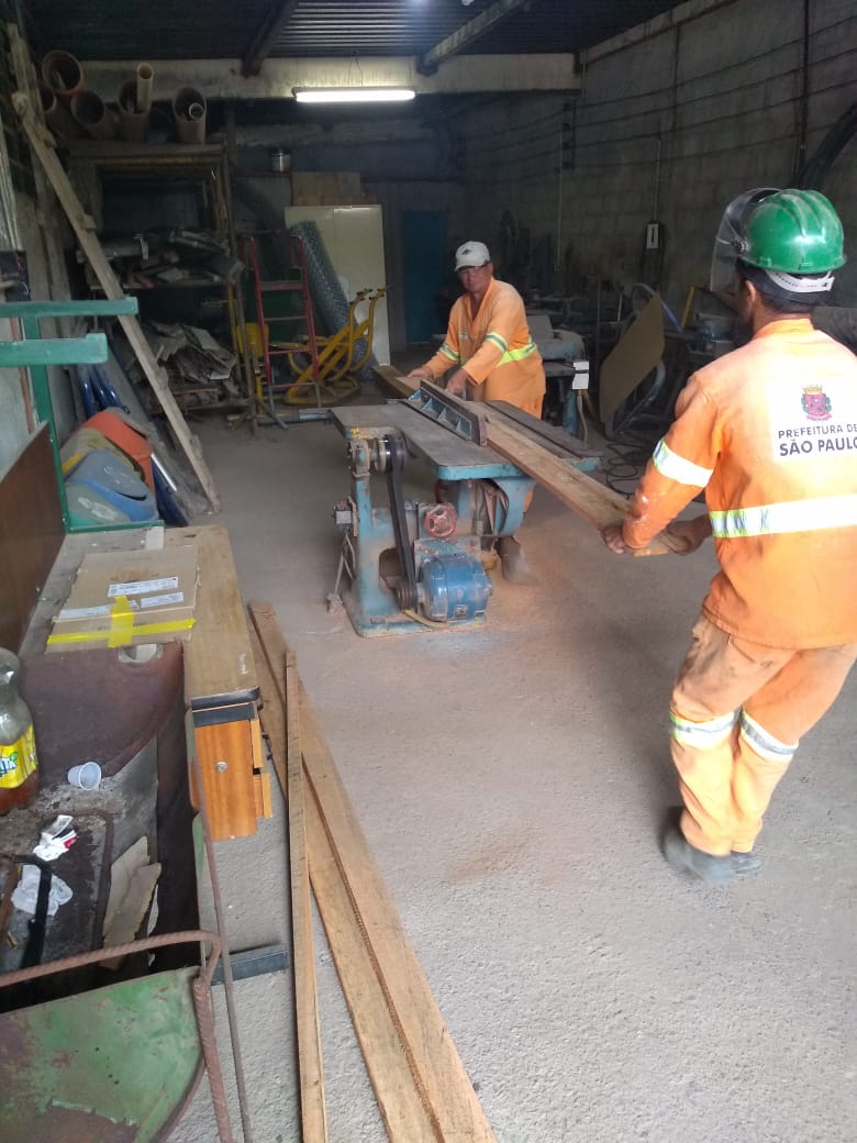 #PraCegoVer - Trabalhadores da Subprefeitura na oficina de carpintaria da Coordenadoria de Obras cortam madeira para montagem do ParCão. O ParCão é feito de aparelhos para proporcionar exercício aos cães.