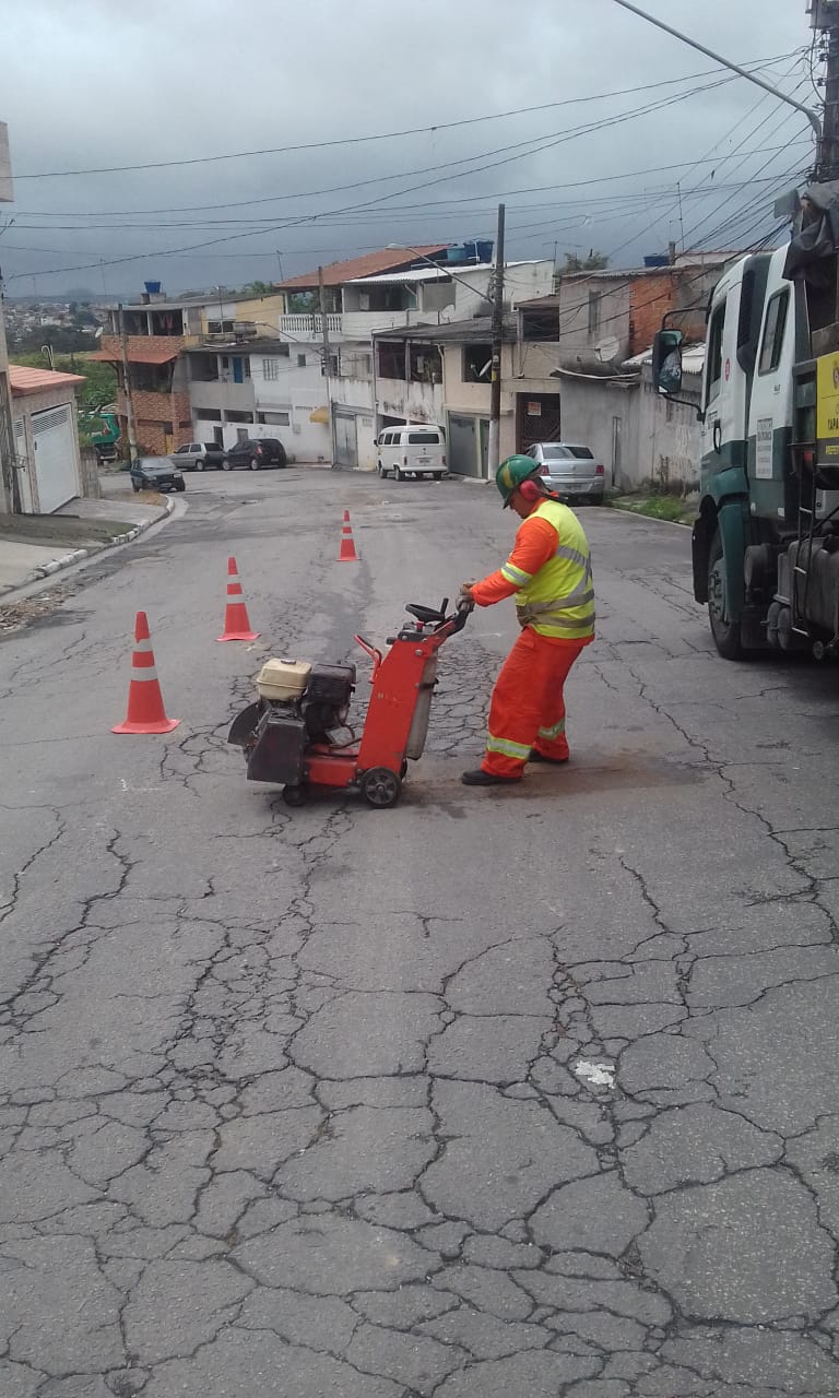 #PraCegoVer - Na primeira foto, um trabalhador da Subprefeitura corta com máquina o asfalto, para demarcar o local do tapa-buraco. Na segunda foto, o buraco já tapado.