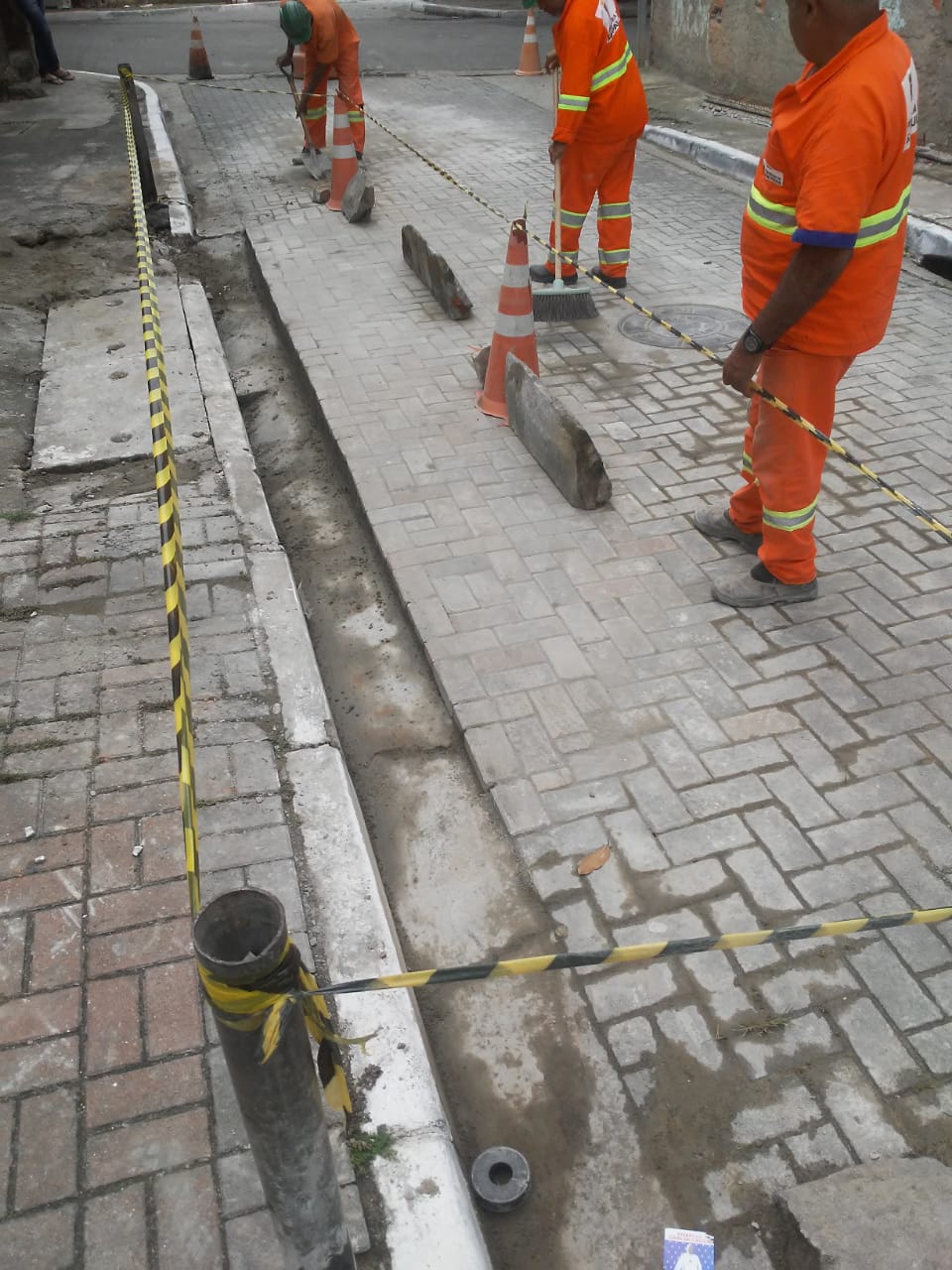 #PraCegoVer - Trabalhadores da Subprefeitura removem os intertravados de concreto que formam o piso da via. Na segunda foto, o piso já recuperado.