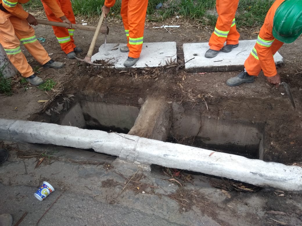 #PraCegoVer - Trabalhadores da Subprefeitura em volta de uma boca-de-lobo, com as tampas retiradas.