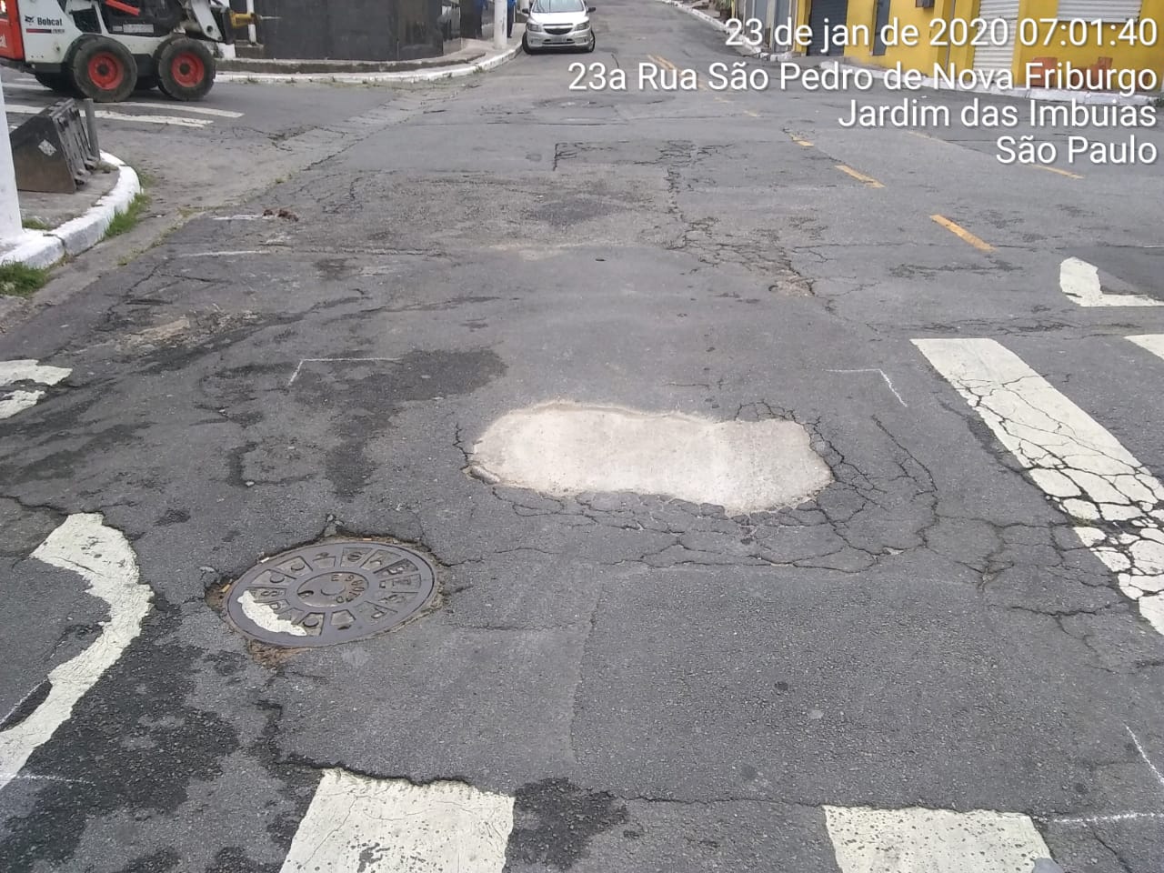 #PraCegoVer - Na primeira foto, vê-se o buraco no centro da via, no meio de uma faixa de pedestres. Na segunda foto, o buraco já tapado.