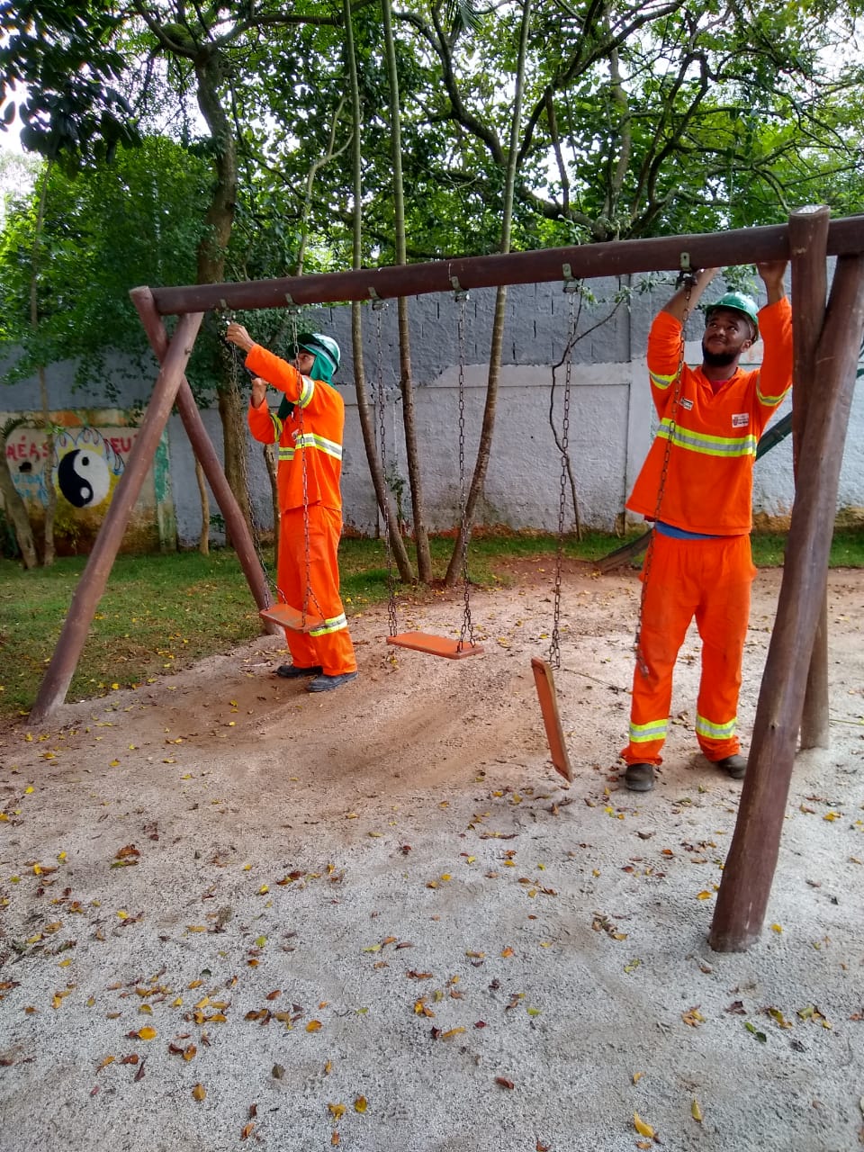 #PraCegoVer - Trabalhadores da Subprefeitura instalam ferragens novas do balanço no local.