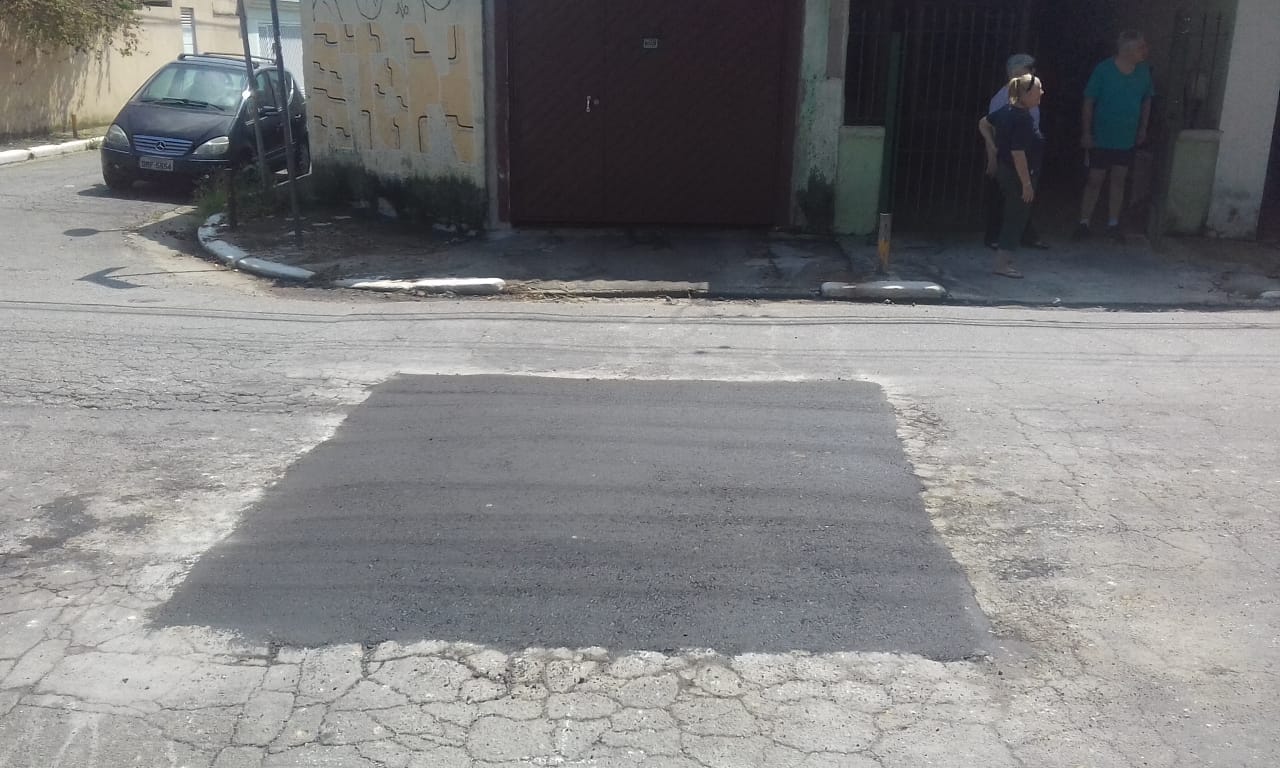#PraCegoVer - Na primeira foto, o buraco no centro da rua. Um trabalhador da Subprefeitura faz o recorte do asfalto. Na foto seguinte, o buraco já tapado.