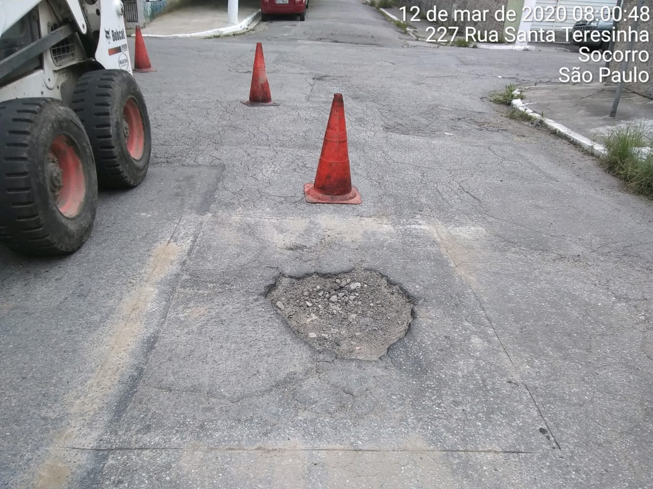 #PraCegoVer - Na primeira foto, o buraco, bem no centro da via, demarcado por cones. Na foto seguinte, o buraco já tapado.