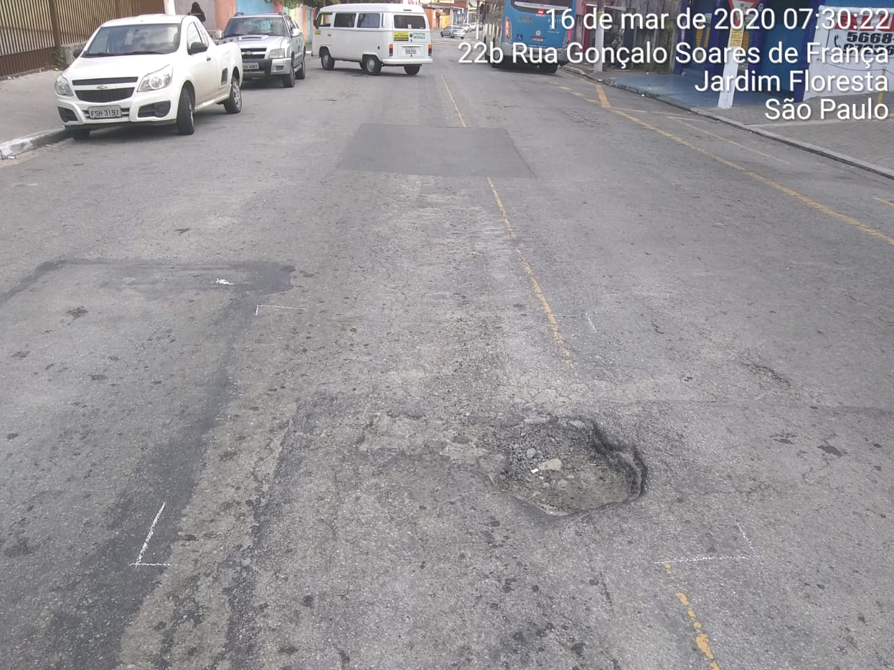 #PraCegoVer - Na primeira foto, o buraco, bem no centro da via. Na foto seguinte, o buraco já tapado.