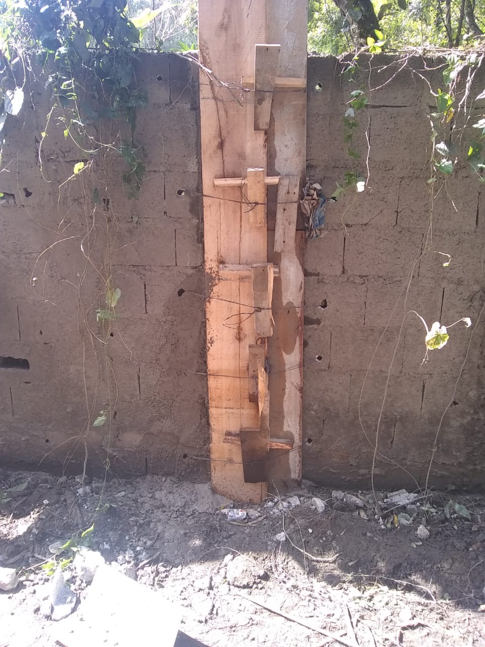 #PraCegoVer - Na primeira foto, o muro com rachadura de alto a baixo, no centro. Na foto seguinte, o muro com forma de madeira, usada para encher a rachadura com concreto.