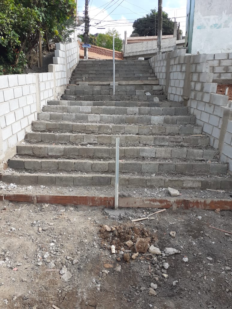 #PraCegoVer - Escadaria da viela em fase final de acabamento. O escadão é ladeado por muros de blocos de concreto.