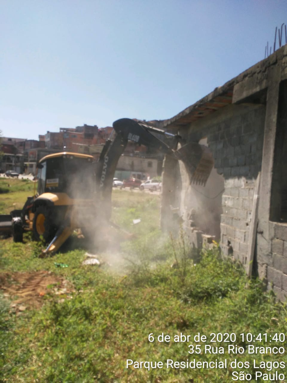 #PraCegoVer - Escavadeira da Subprefeitura derruba construção ilegal na via.