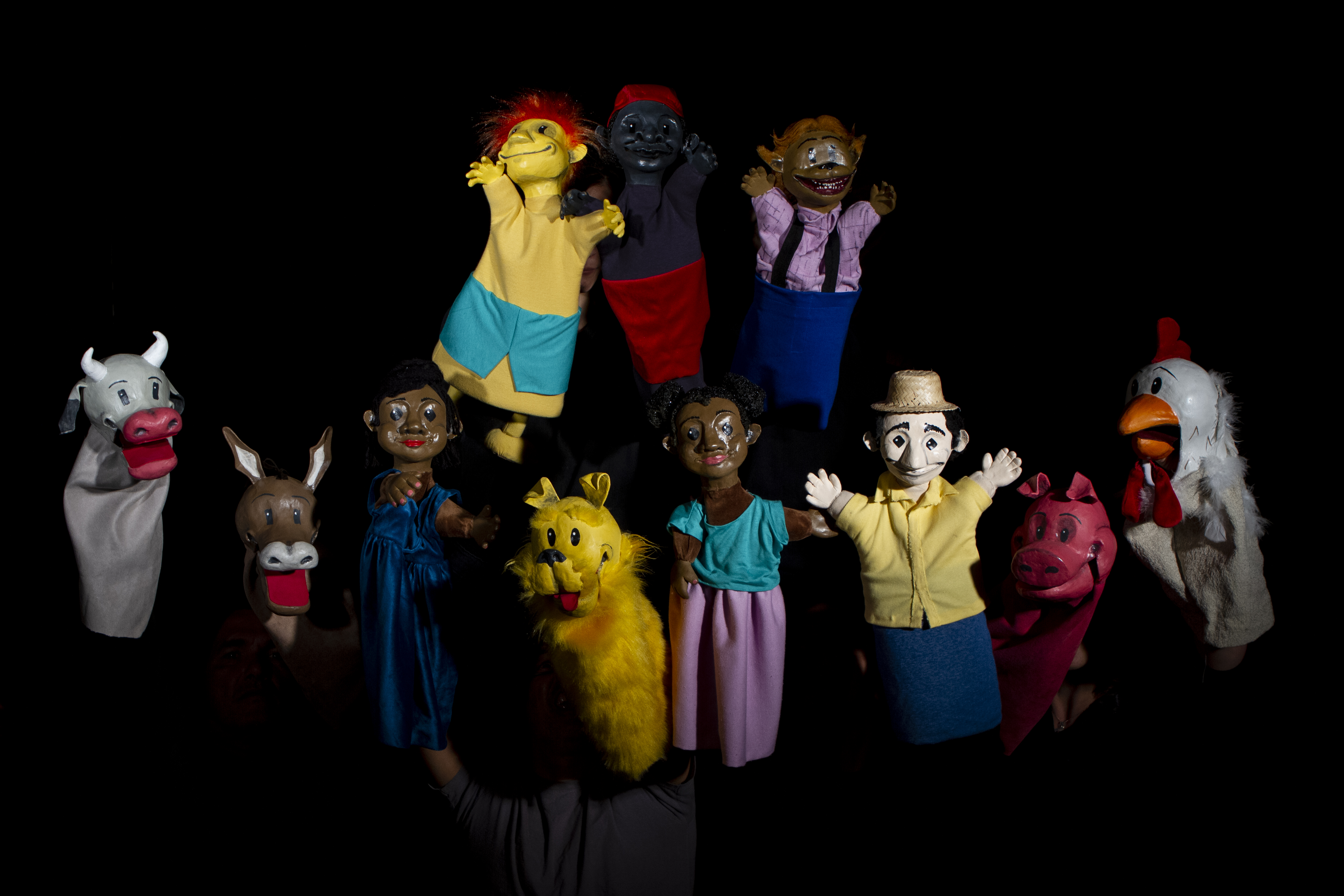 Imagem de nove fantoches usados no espetáculo, personagens como saci, curupira e lobisomem podem ser identificados.