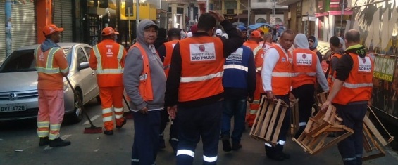 Pessoal de fiscalização recolhendo caixotes de madeira do meio da rua