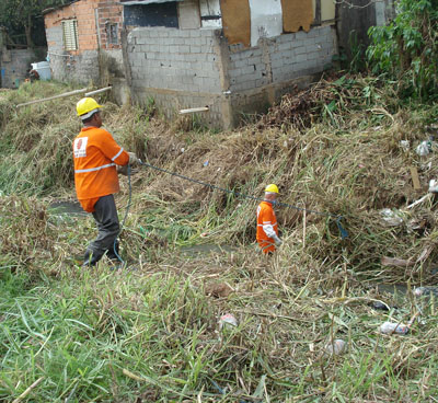 Equipe realizando serviço de limpeza manual em Córrego