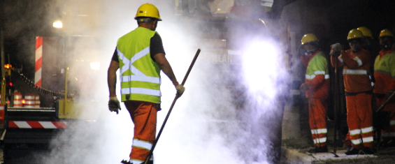 Homens informatizados com roupas da prefeitura da Cidade de São Paulo com equipamentos adequados, capacete, espalhando pinchem na avenida
